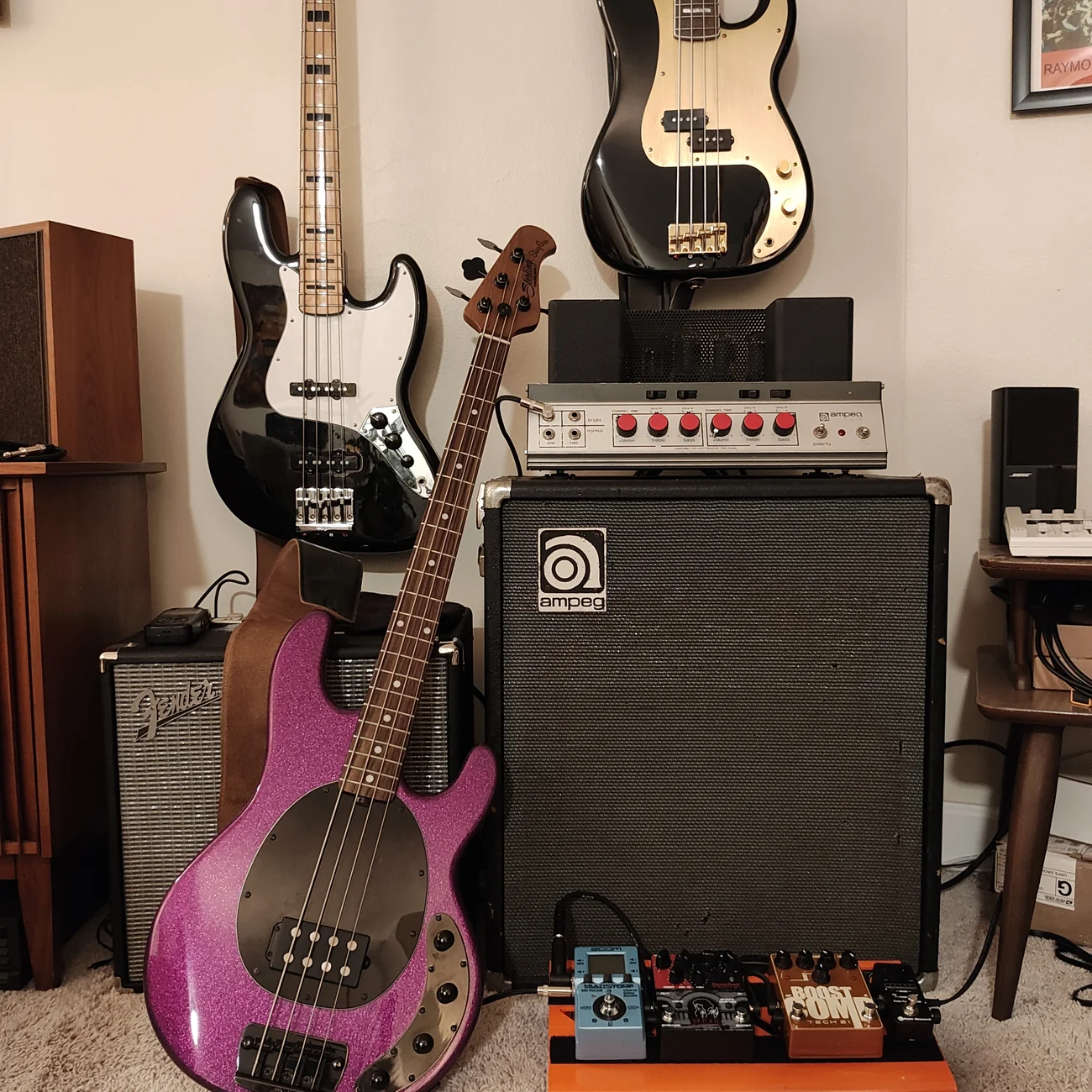 A collection of various bass guitars, amplifiers, and effect pedals